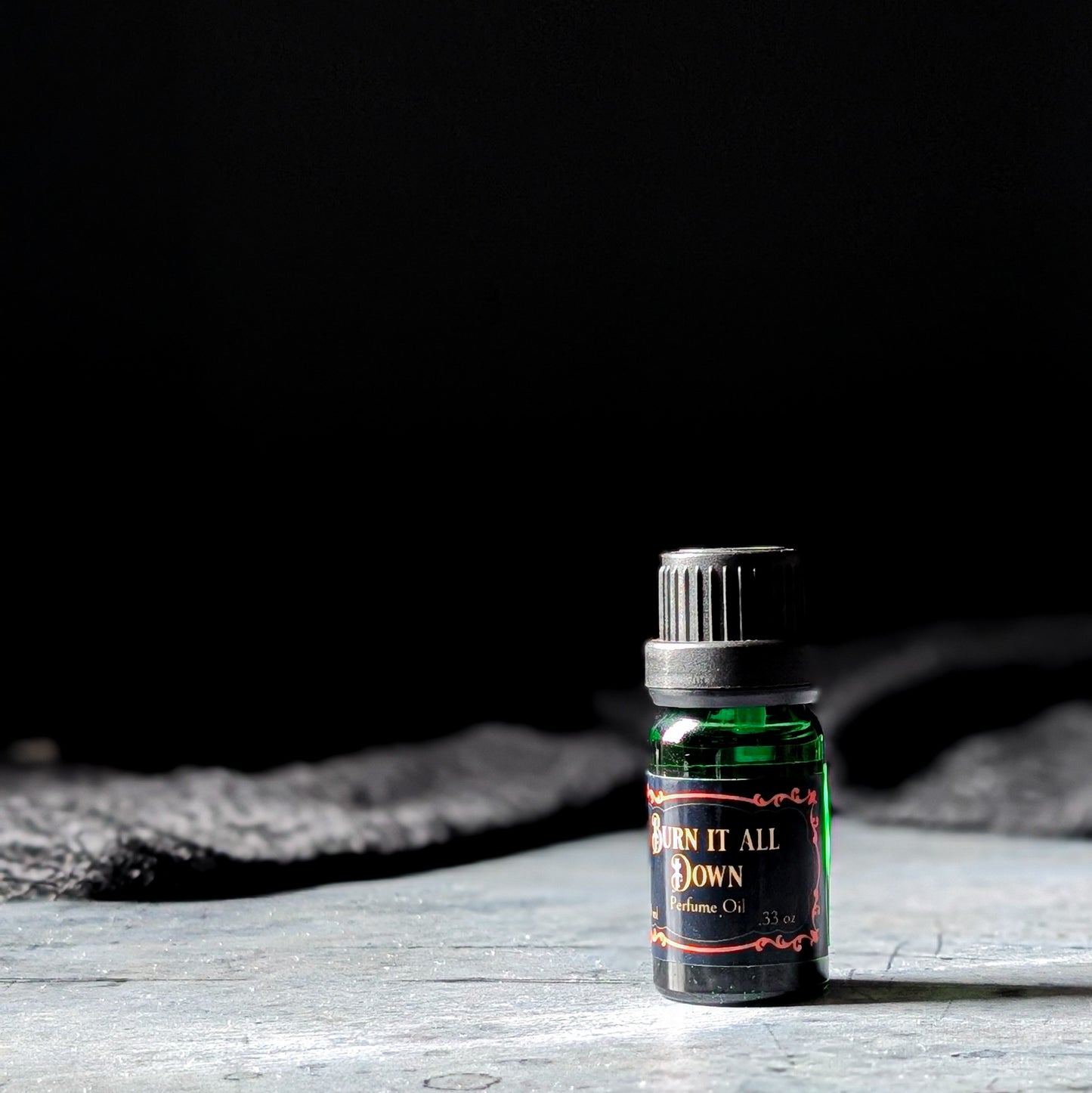 Burn it All Down perfume oil on a dark background
