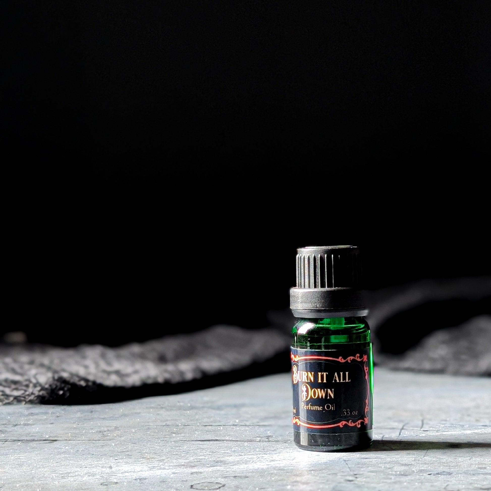 Burn it All Down perfume oil on a dark background